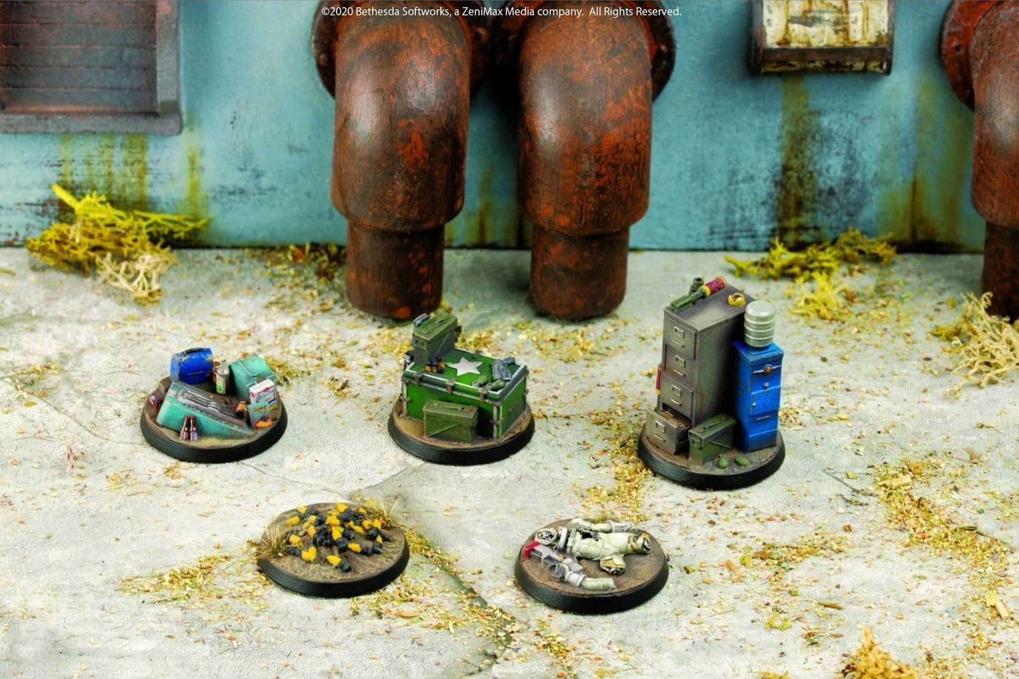 Five miniature objective markers on bases: junk, crates, a filing cabinet, and a fallen figure