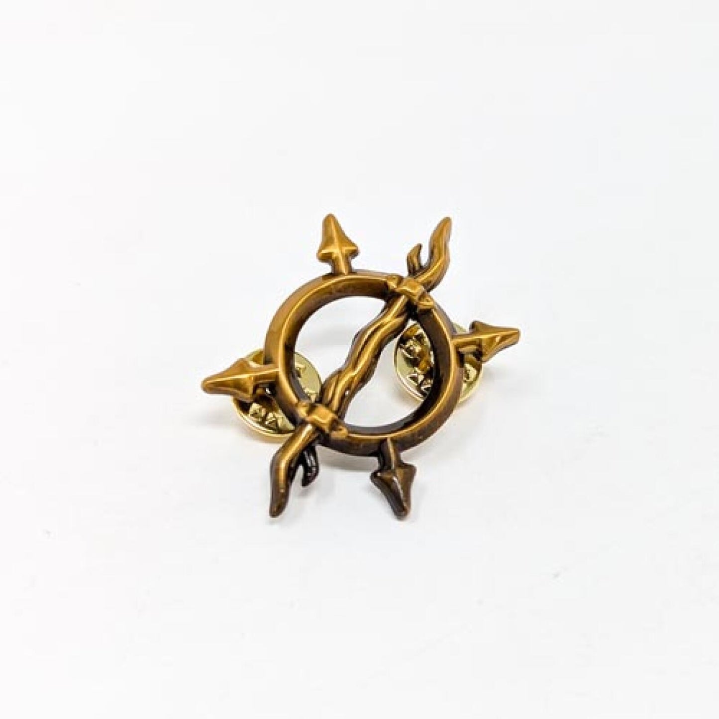 Bronze compass rose pin with a bow and arrow design crossing the center, on a white background.