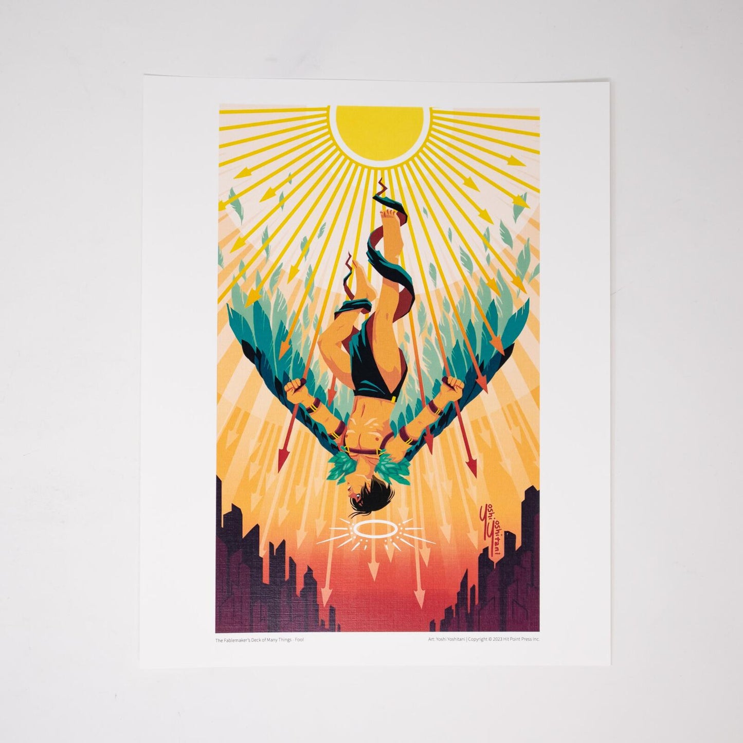 Vibrant art print of a man hanging upside down by one bound leg, a halo below his head, sun rays above a dark cityscape