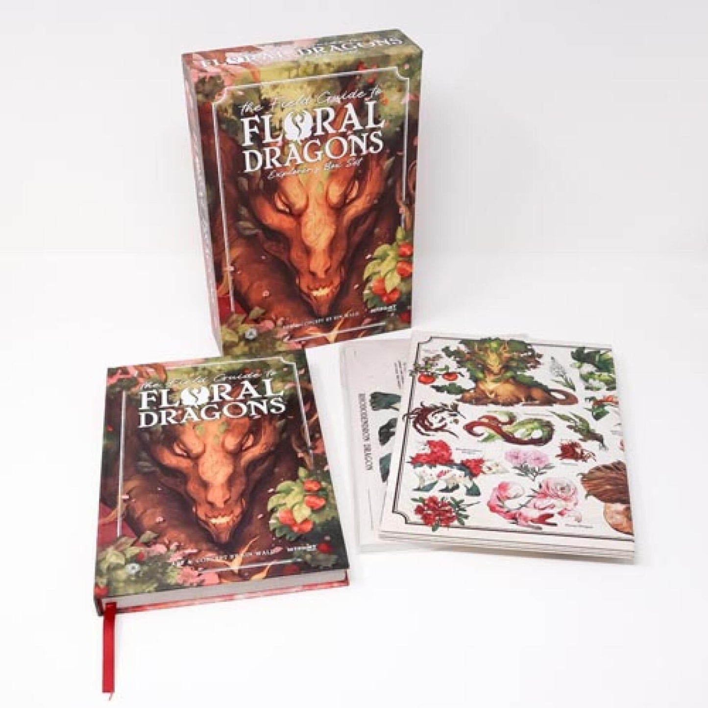 A "Floral Dragons" box set, book with red bookmark, and botanical art prints, all featuring plant-like dragons