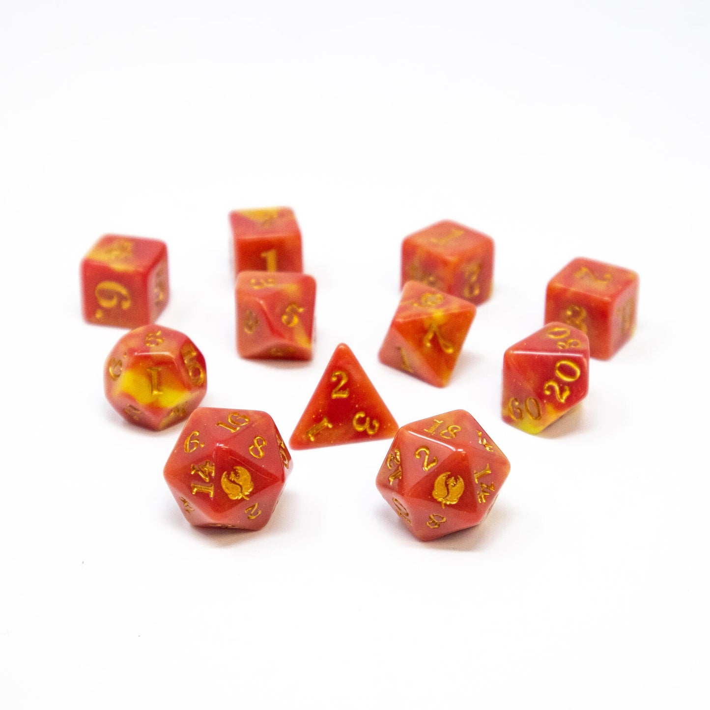 Red and yellow marbled polyhedral dice with gold numbers, scattered on a white surface.