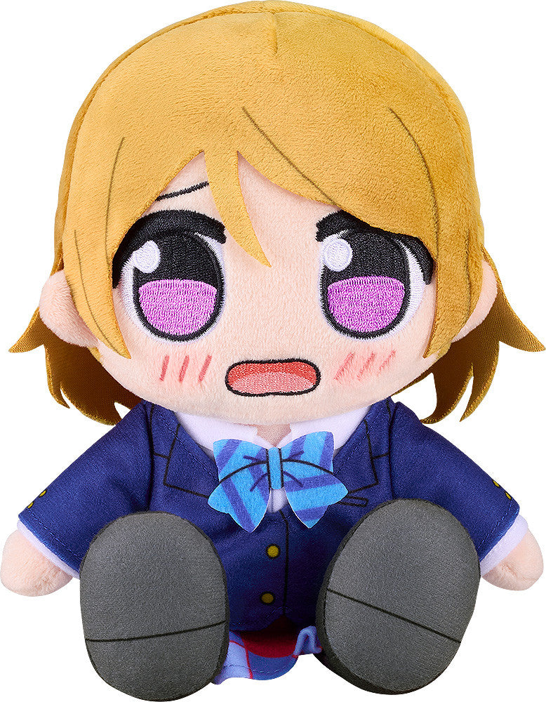 A Good Smile Company LoveLive! Kuripan Hanayo Koizumi plushie featuring blonde hair, large purple and black eyes with blush marks, wearing a blue school uniform and striped bow tie, sitting upright