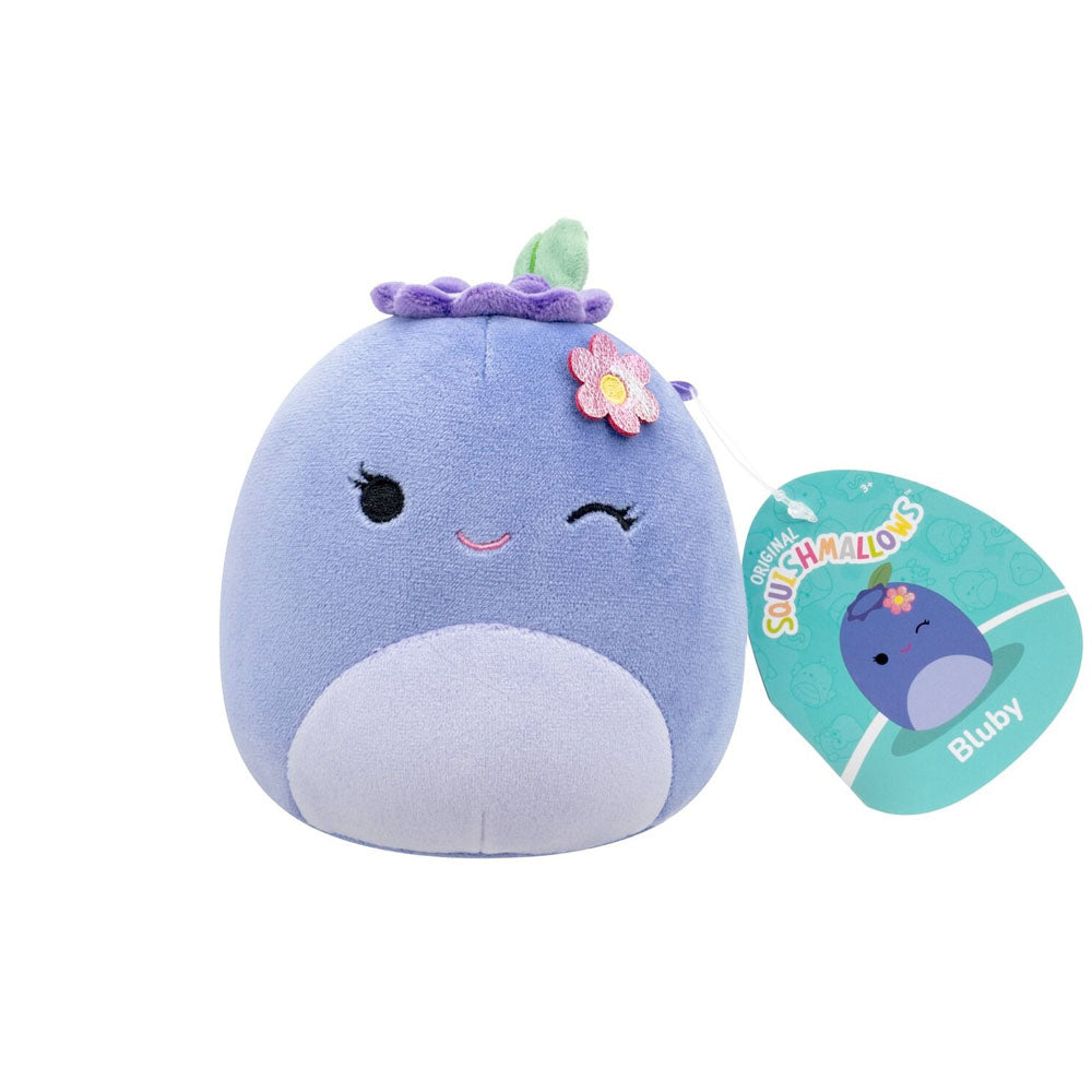 Purple Bluby the blueberry Squishmallows plush, winking with a flower on its head, displayed with its tag
