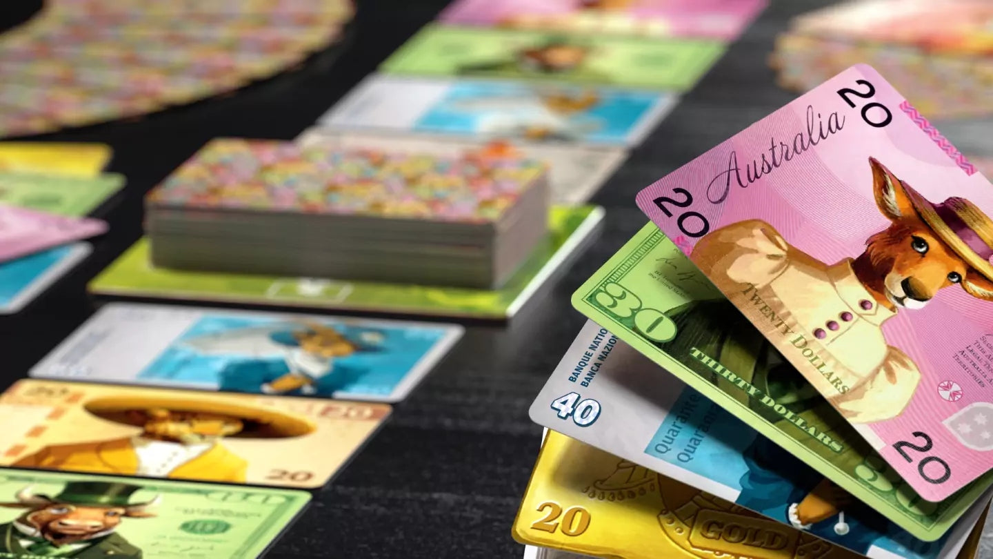Colorful board game money cards are fanned out on a table, featuring animal characters dressed in suits and hats