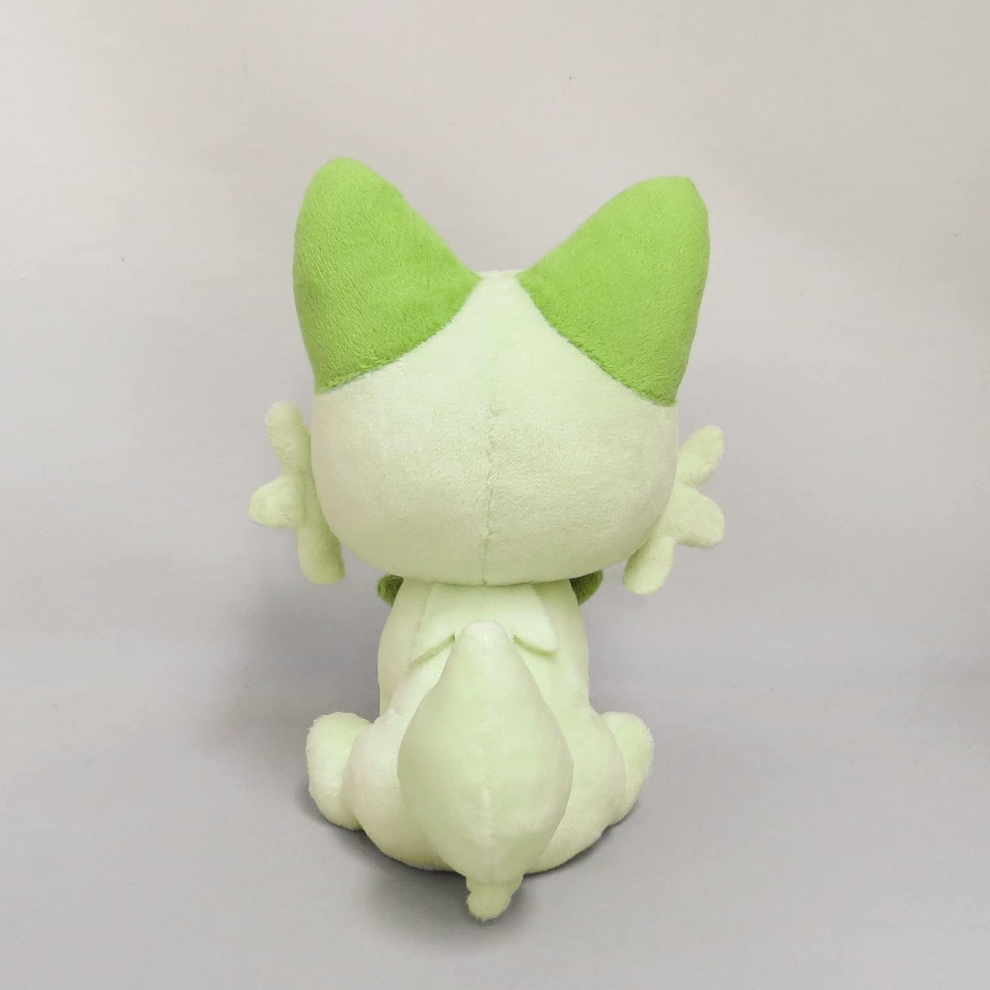 Pokémon Sprigatito plush toy, light green, sitting and viewed from the back