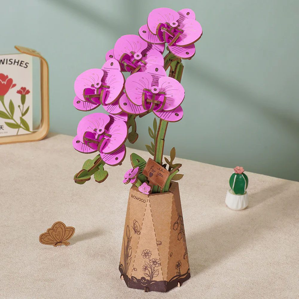 The assembled purple wooden moth orchid stands upright in its patterned cardboard vase with a small decorative "For you" plaque attached
