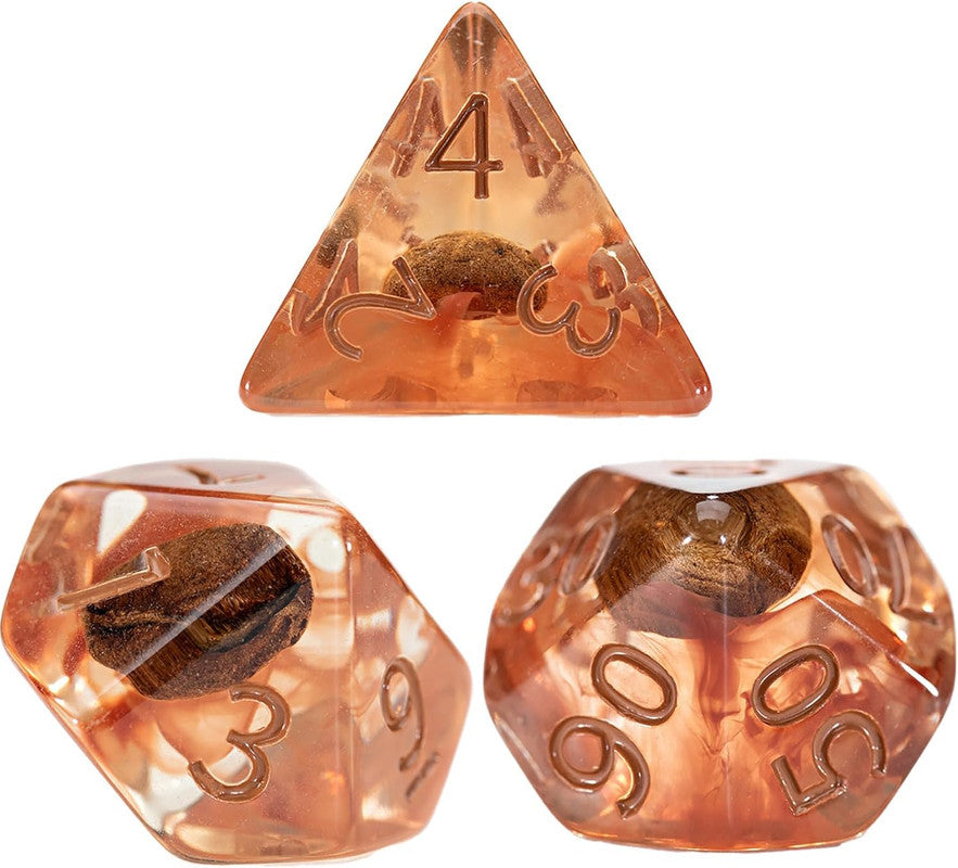 Three translucent amber polyhedral dice, each with a coffee bean suspended inside and etched numbers