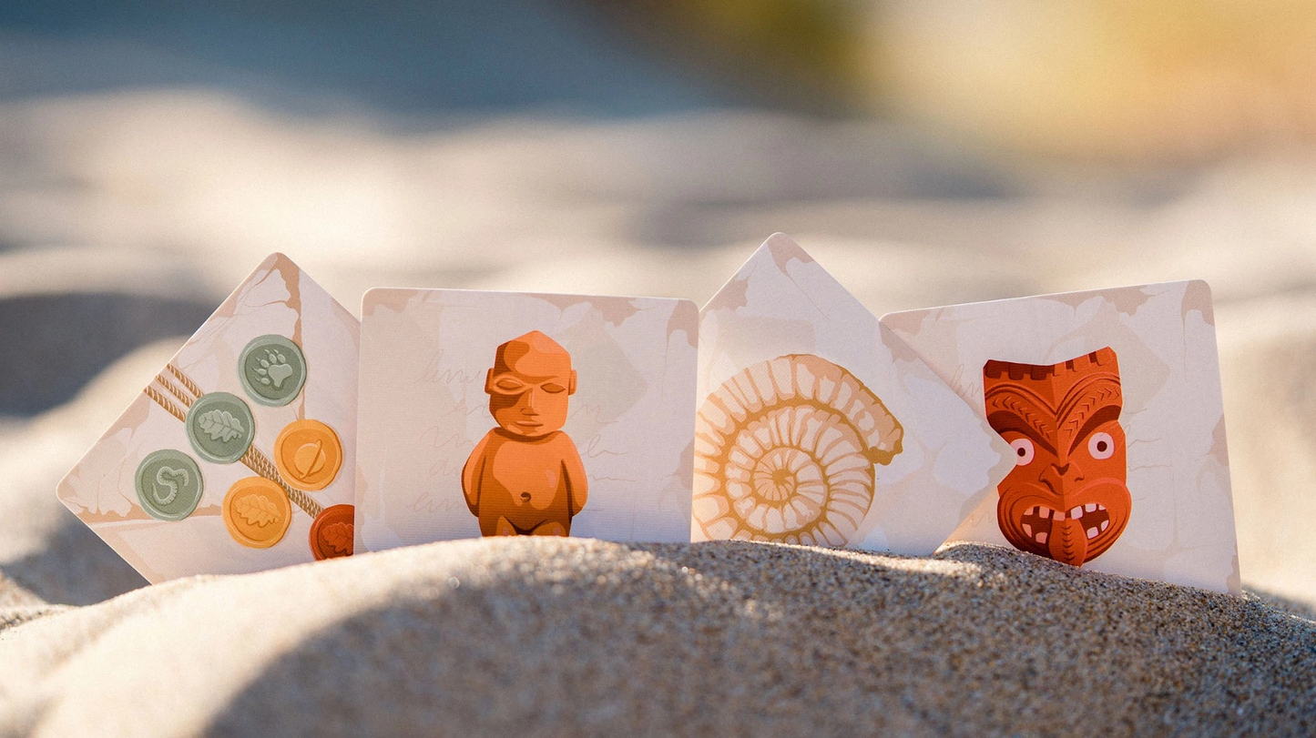 Toko Island game cards spread on sand