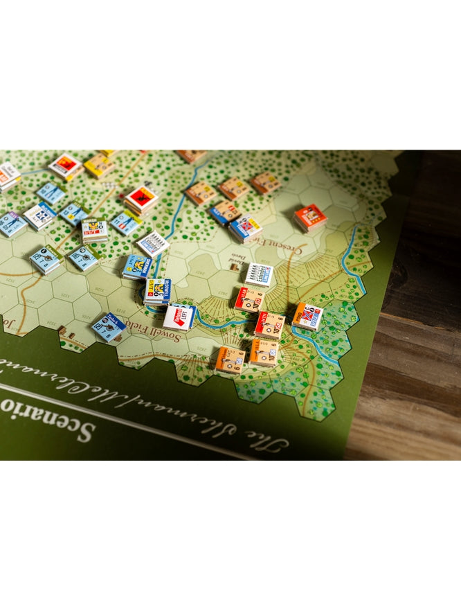 Green and tan hexagonal wargame map with numerous colorful square unit tokens placed on its terrain