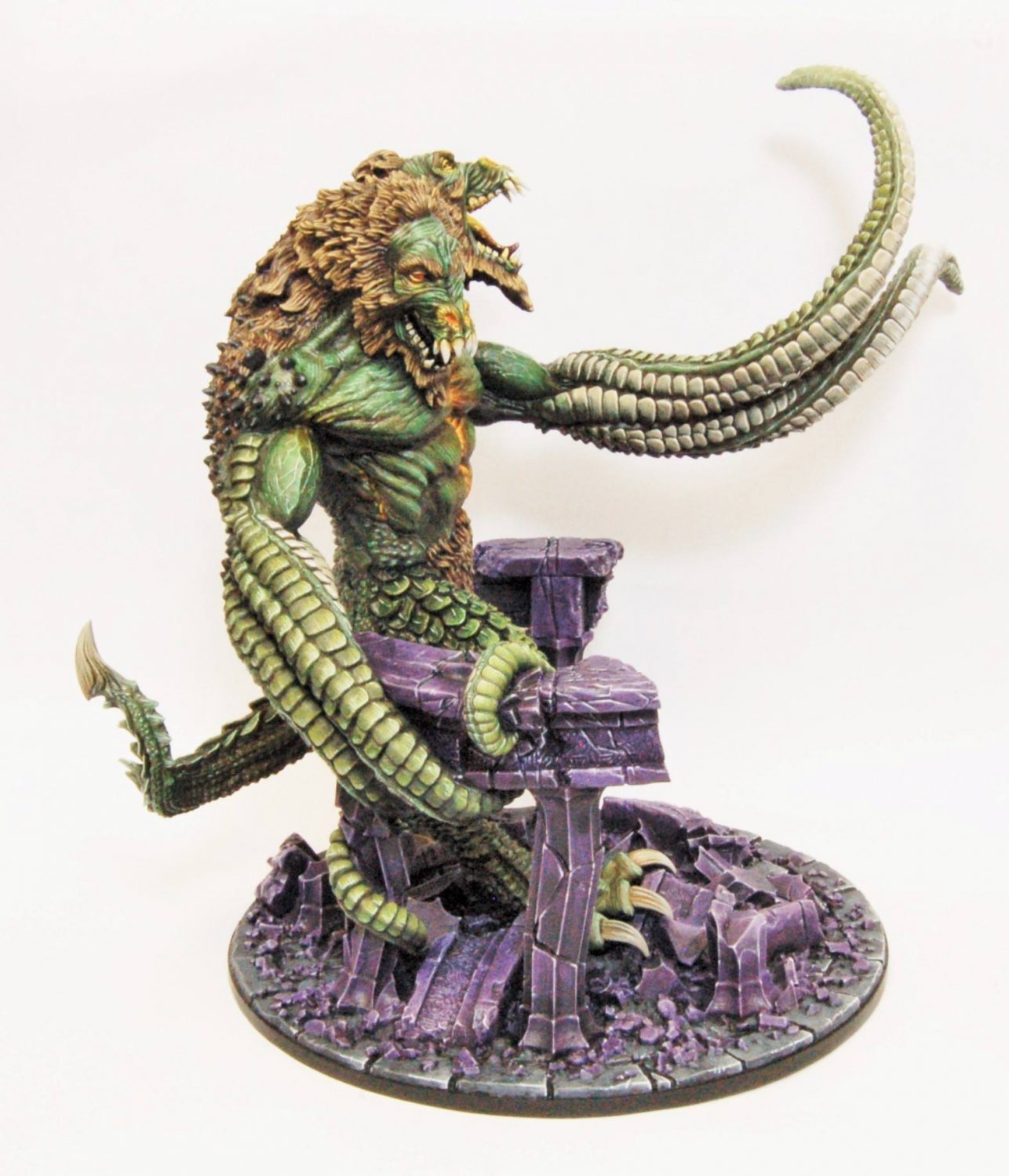 A Dungeons & Dragons Demon Lord Demogorgon miniature, a two-headed green monster with tentacles and scales on a purple ruined base