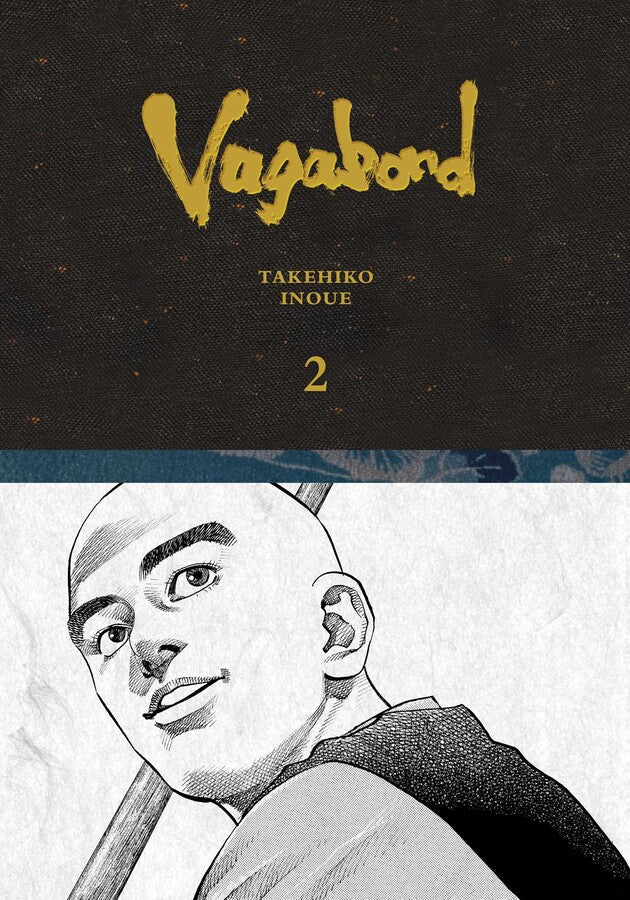 Vagabond Definitive Edition Volume 2 Book cover with a golden title, author, and volume number on a dark background above a smiling bald manga character holding a staff