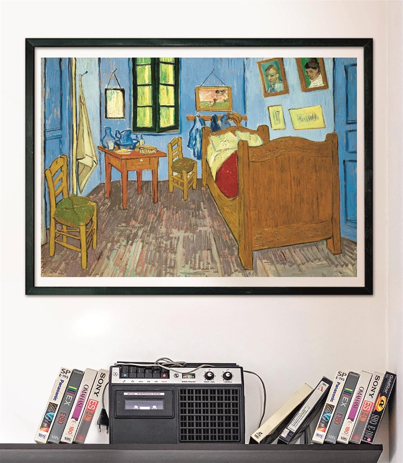 Framed print of Van Gogh's "The Bedroom" painting, with a cassette player and VHS tapes on a shelf below