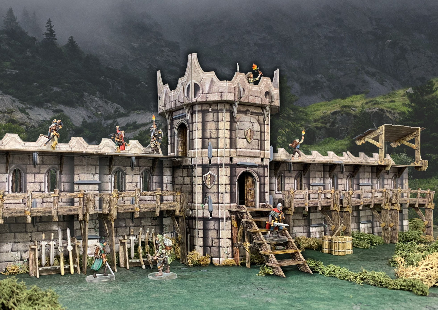 Miniature stone castle with figures on walls, tower, and ground. They stand guard, some with torches, against a misty forest.