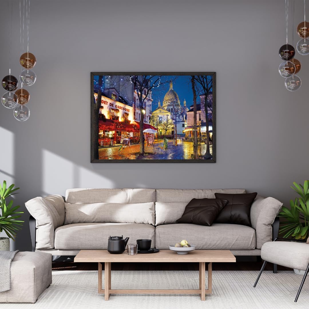 Framed painting depicts Sacré-Cœur, an illuminated cafe, and a wet Paris street with reflections at night