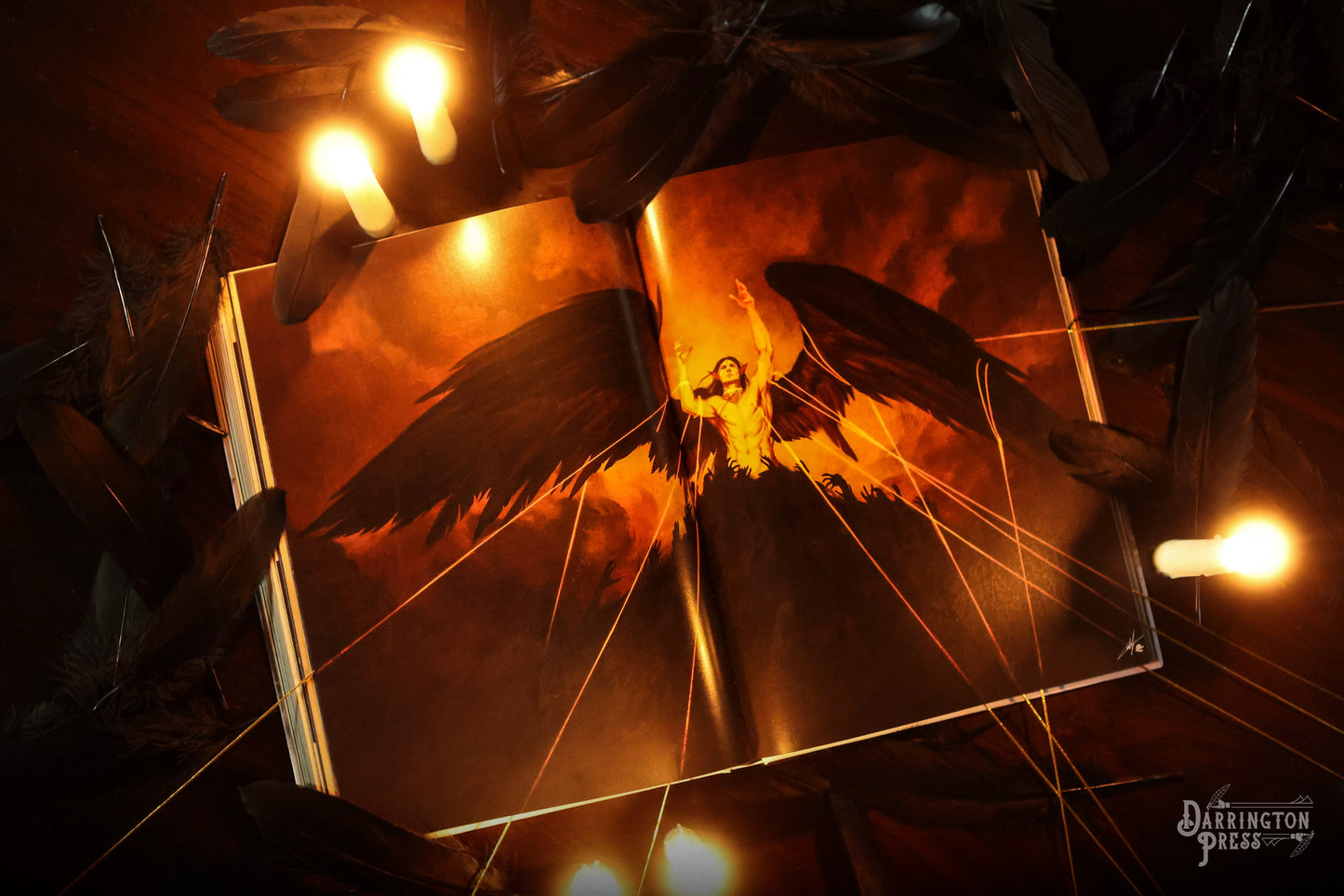 An open book reveals a winged figure with raised arms against a fiery backdrop. Black feathers and small glowing lights surround it