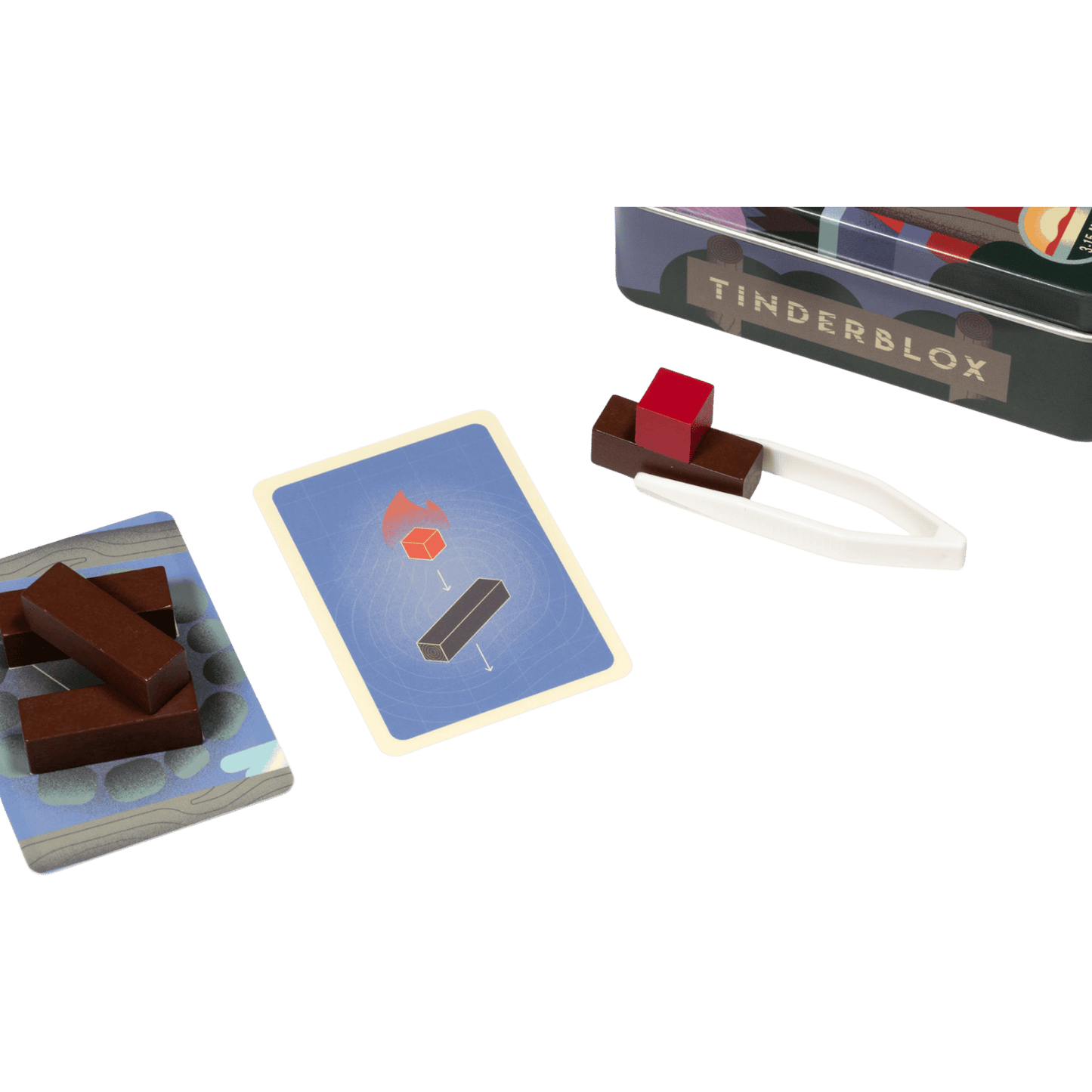 Tinderblox game set: wood blocks, challenge cards, white tongs holding a red block, and the game tin