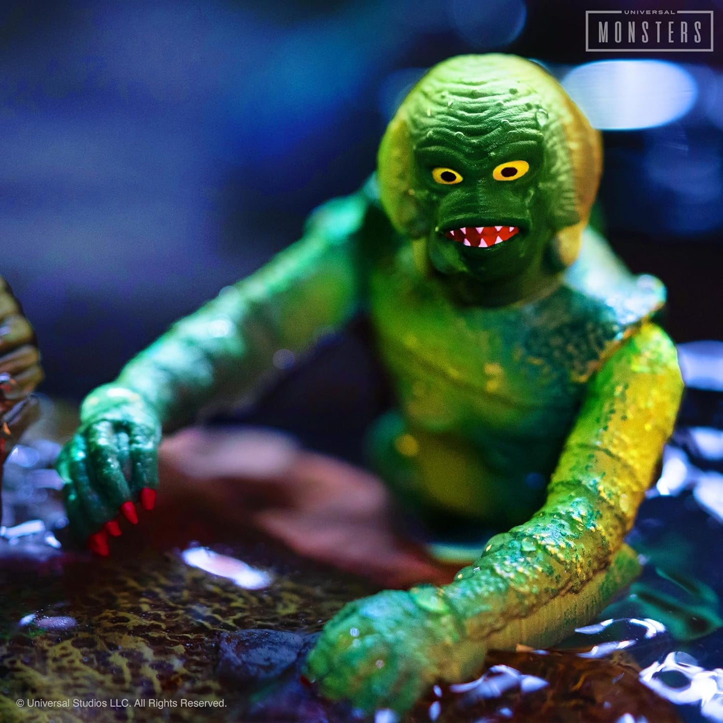 Green Creature from the Black Lagoon figure with striking yellow eyes and red teeth, emerging from dark, murky water