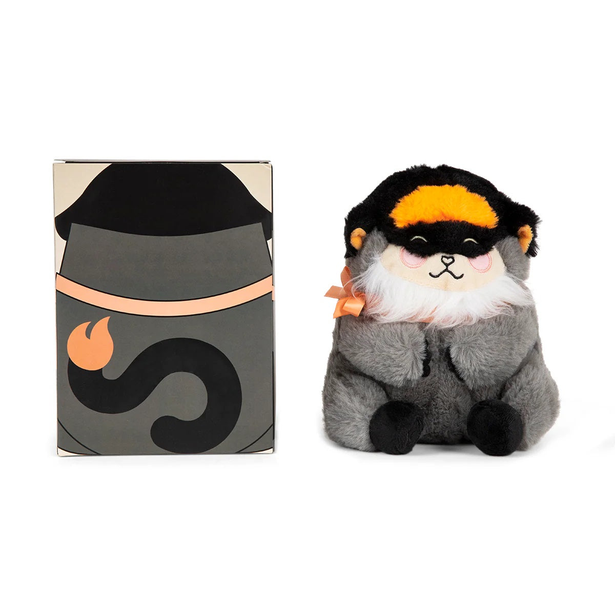 Fluffy grey and black masked plush animal with orange crest and bow, smiling, sits next to its gray stylized box