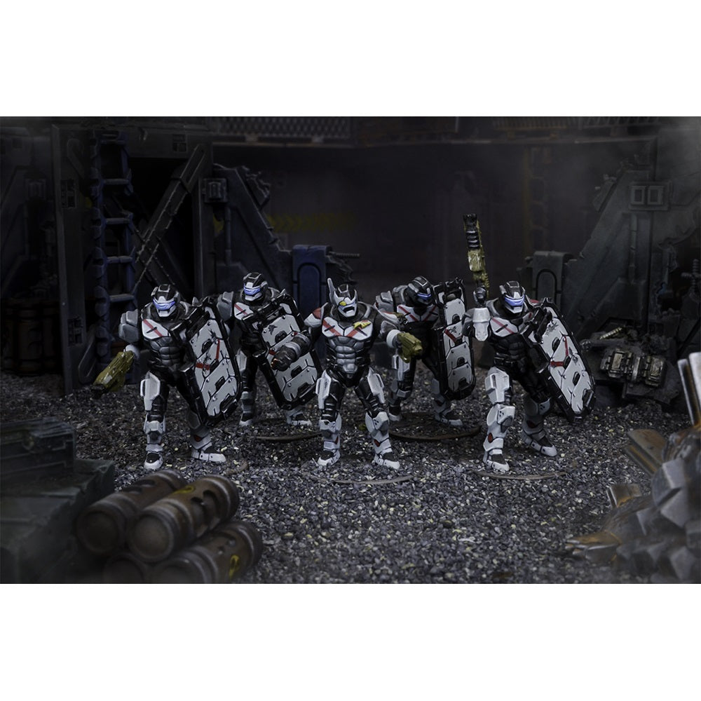 Five futuristic armored miniatures with white/black armor, chest X-marks and shields stand in a dark, industrial scene.