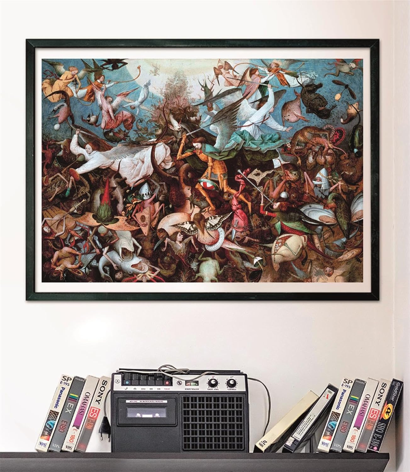 A framed painting depicting angels battling grotesque monstrous creatures, mounted above a shelf with a vintage cassette player and VHS tapes