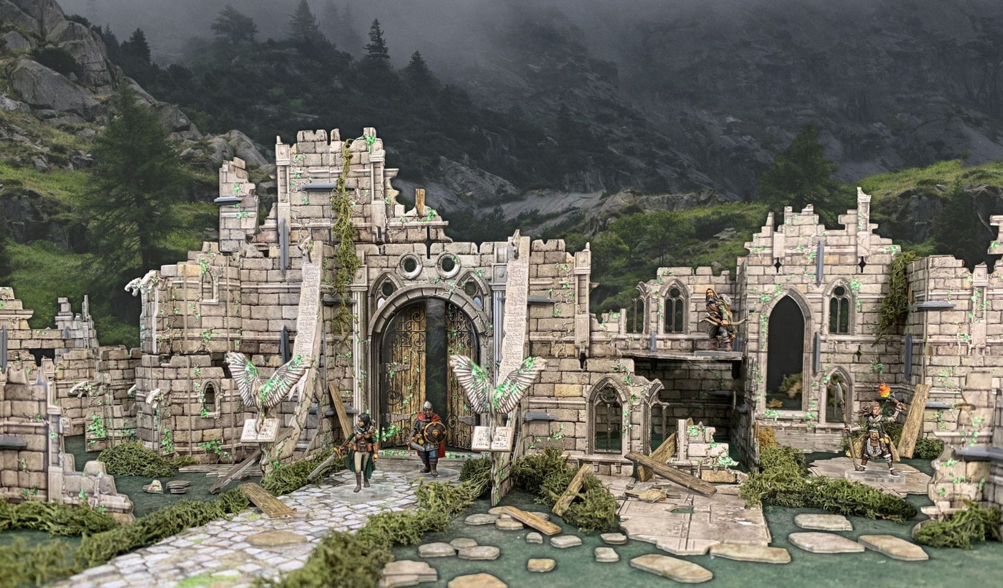 Miniature adventurers explore a moss-covered ruined castle gate against a backdrop of misty mountains.