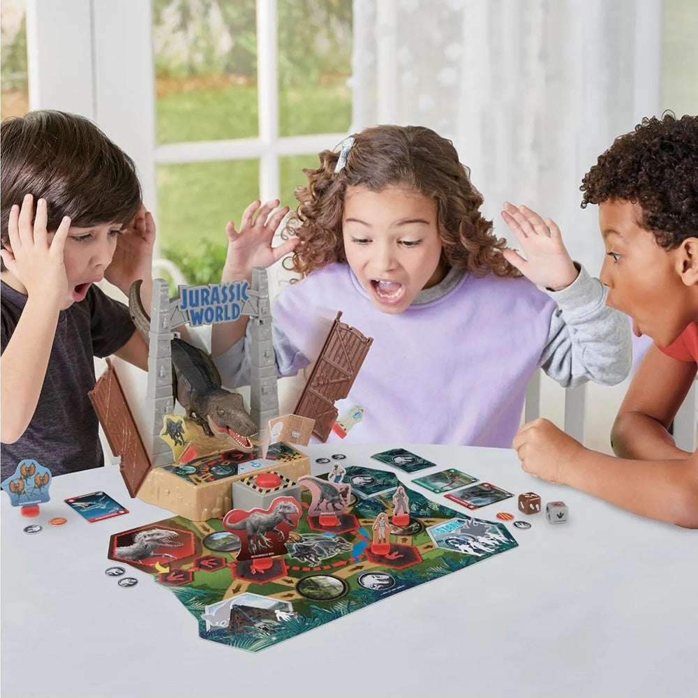 Three children react with wide eyes and open mouths as a T-Rex bursts from a gate in their Jurassic World board game