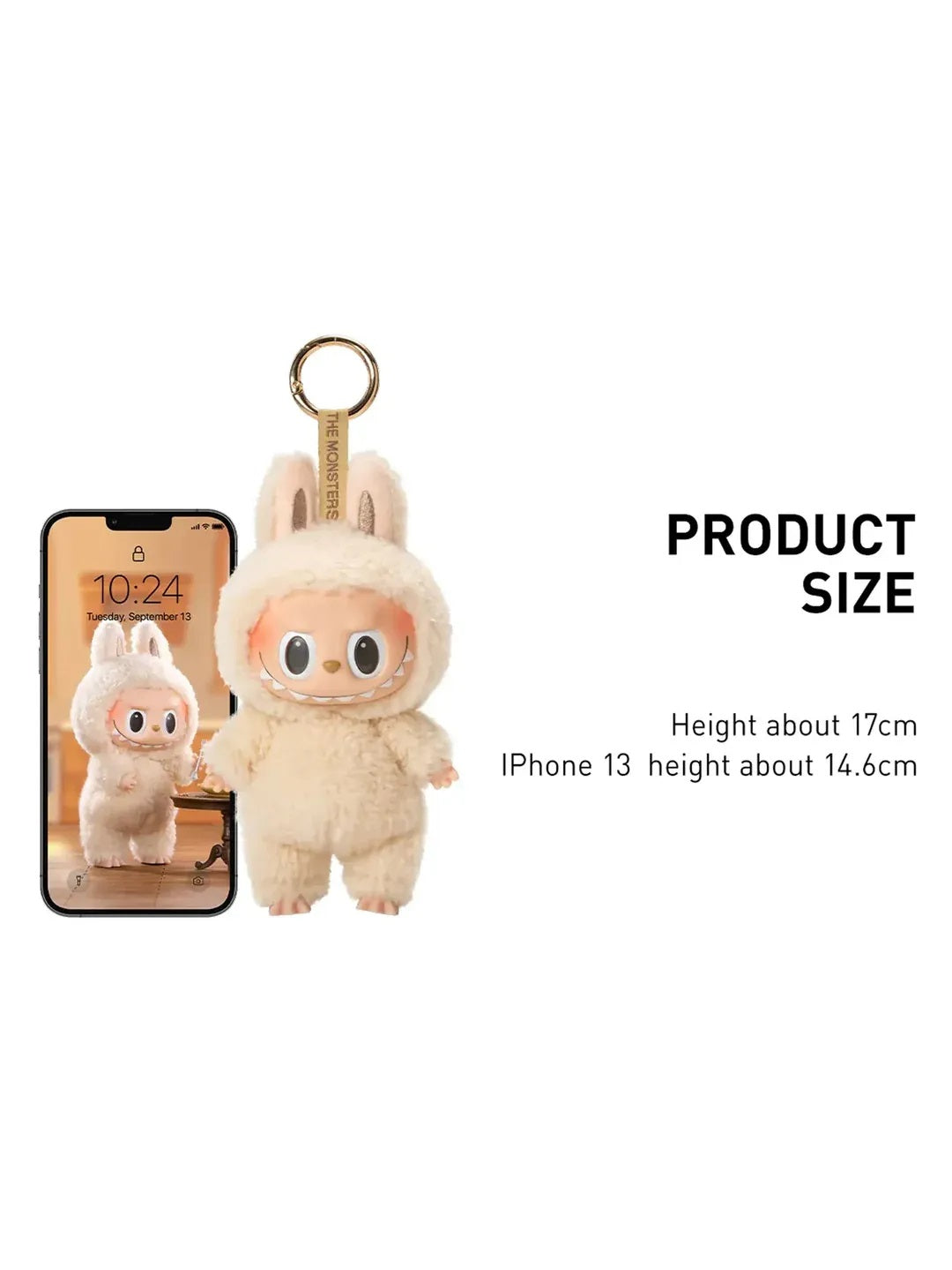 Smiling monster keychain with bunny hood shown next to an iPhone for size comparison