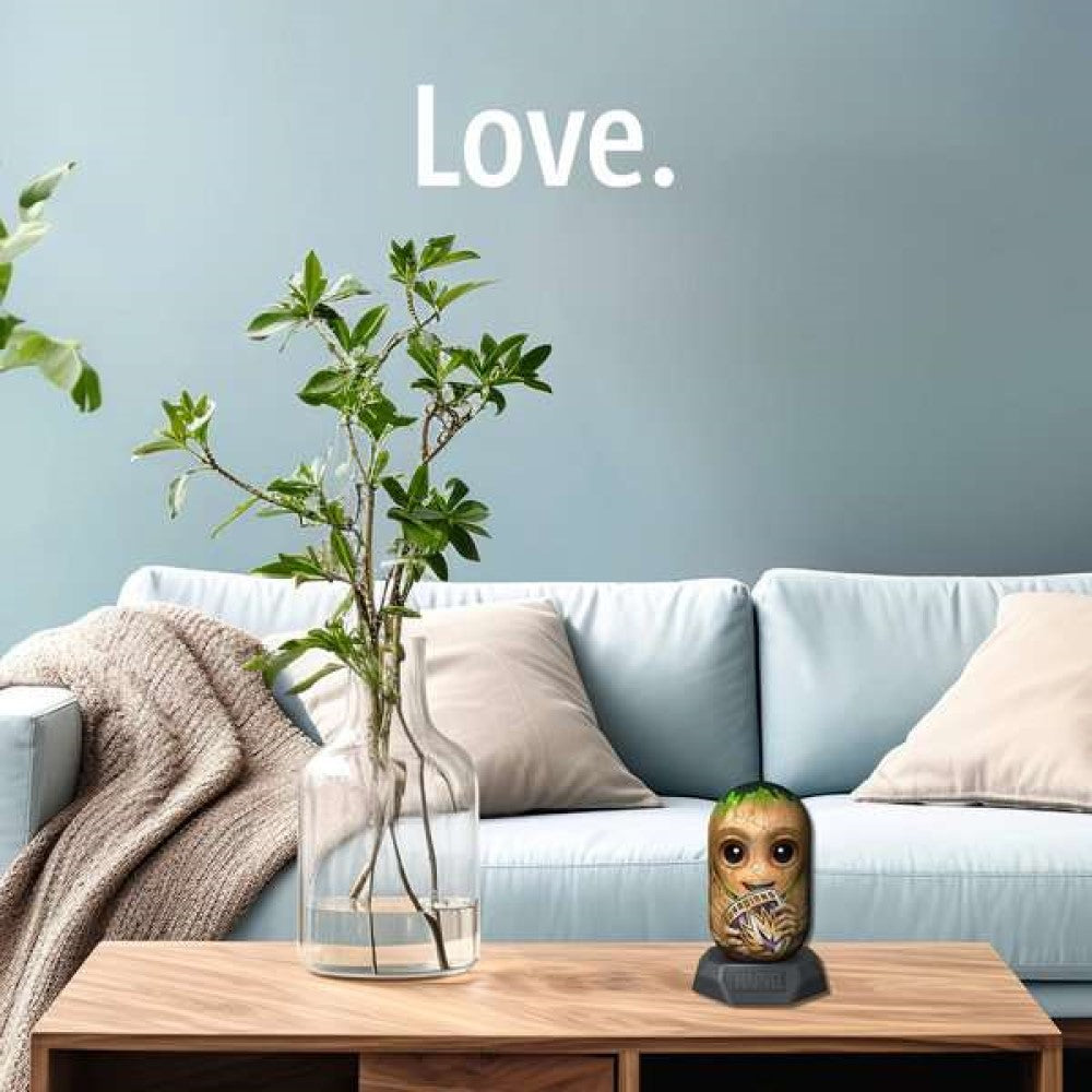 A Baby Groot Marvel figure holding a "Guardians" sign sits on a coffee table in a modern living room