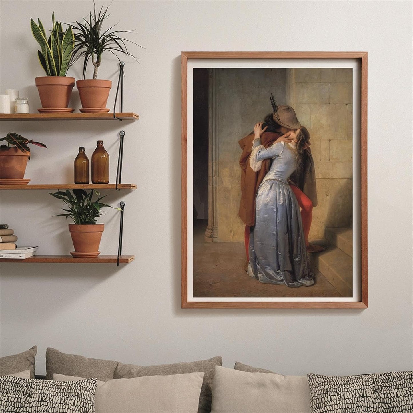 A framed painting of a couple kissing passionately hangs in a modern living room with plants on shelves