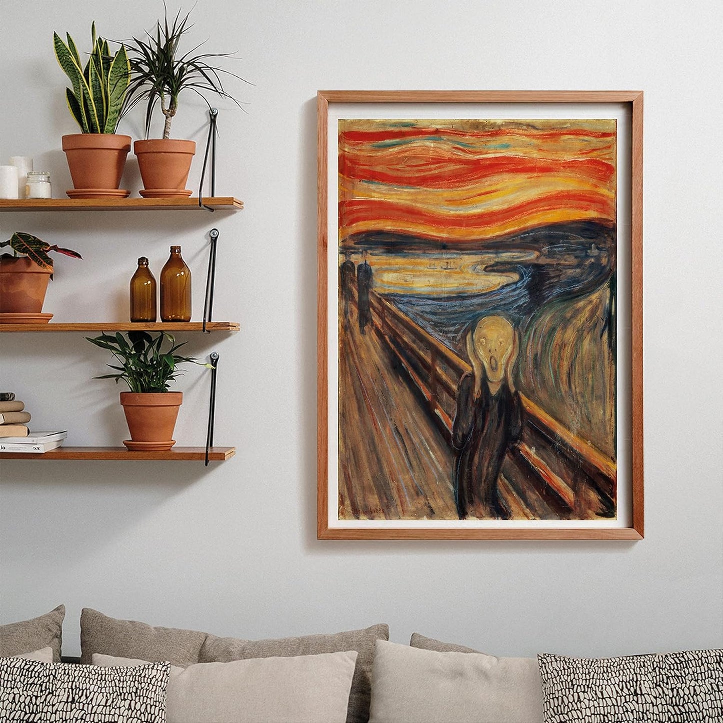 A framed print of Edvard Munch's "The Scream" painting hangs on a wall in a living room, above a couch