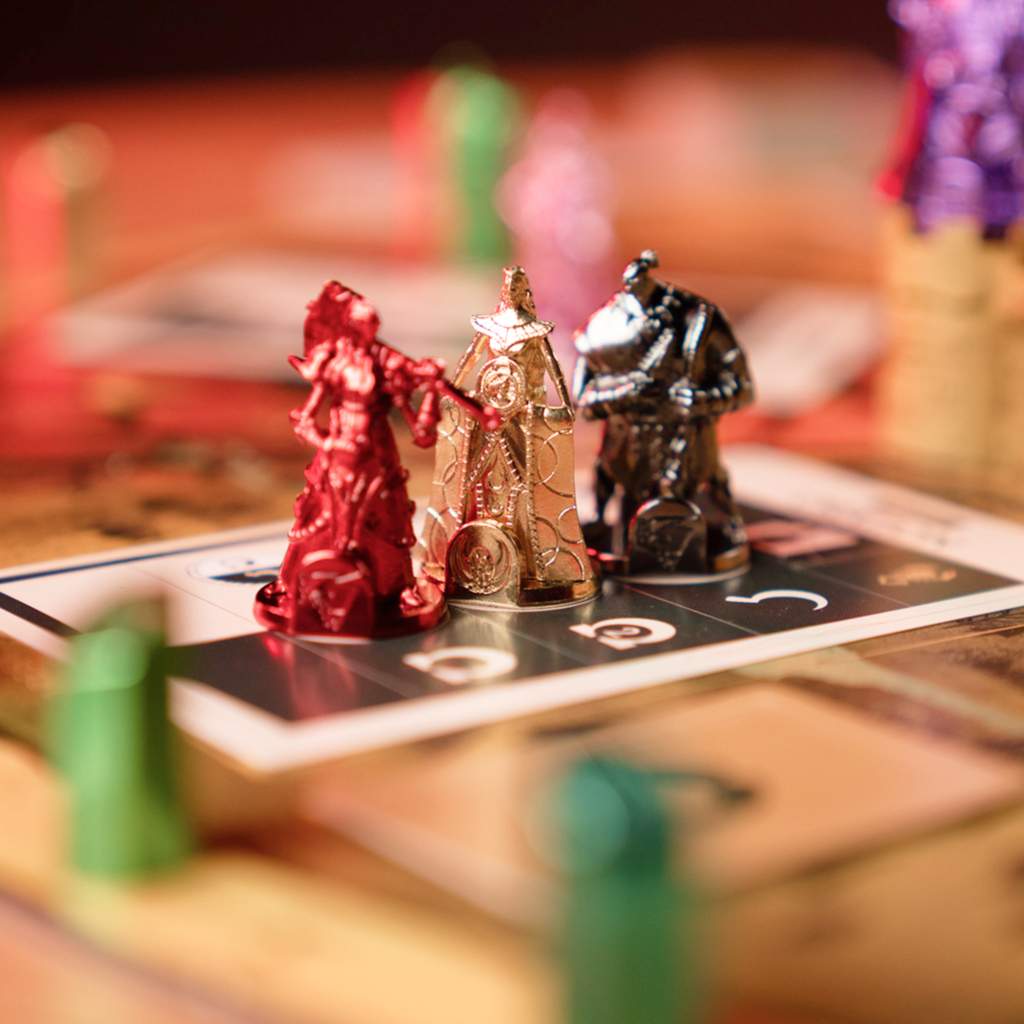 Close-up of red, gold and dark metal fantasy miniatures on a board game section