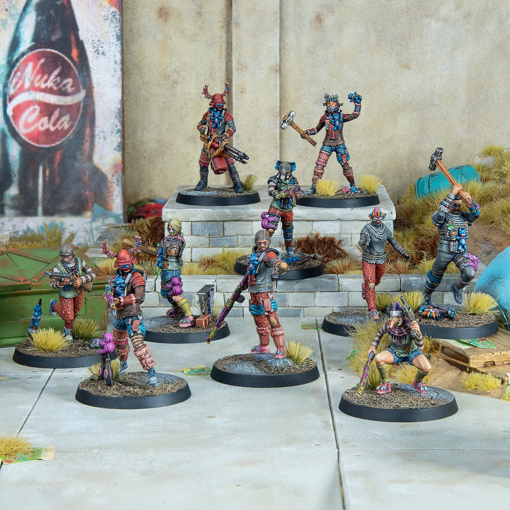 Ten painted Fallout miniatures depicting diverse wasteland raiders, armed with various weapons, posed on a diorama with a Nuka-Cola sign