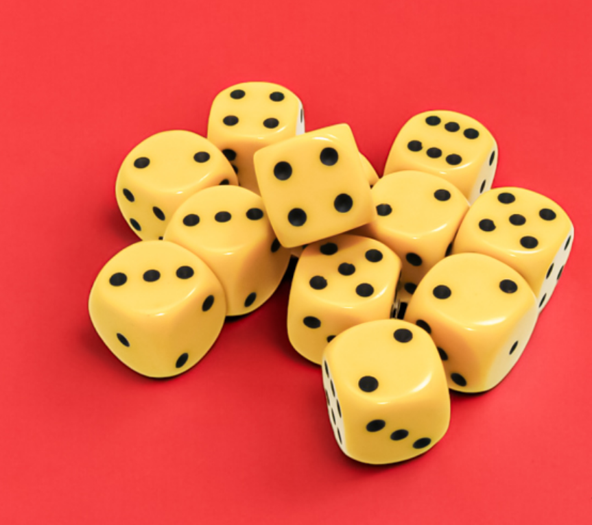 Yellow dice with black pips piled on a solid red surface