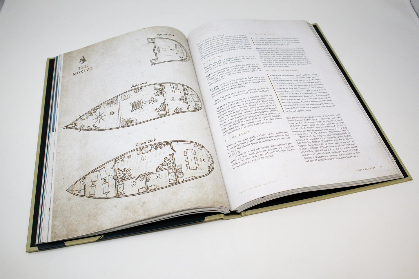 Open rulebook displaying detailed ship deck plans for "The Moxi VII" on the left page and descriptive text on the right.