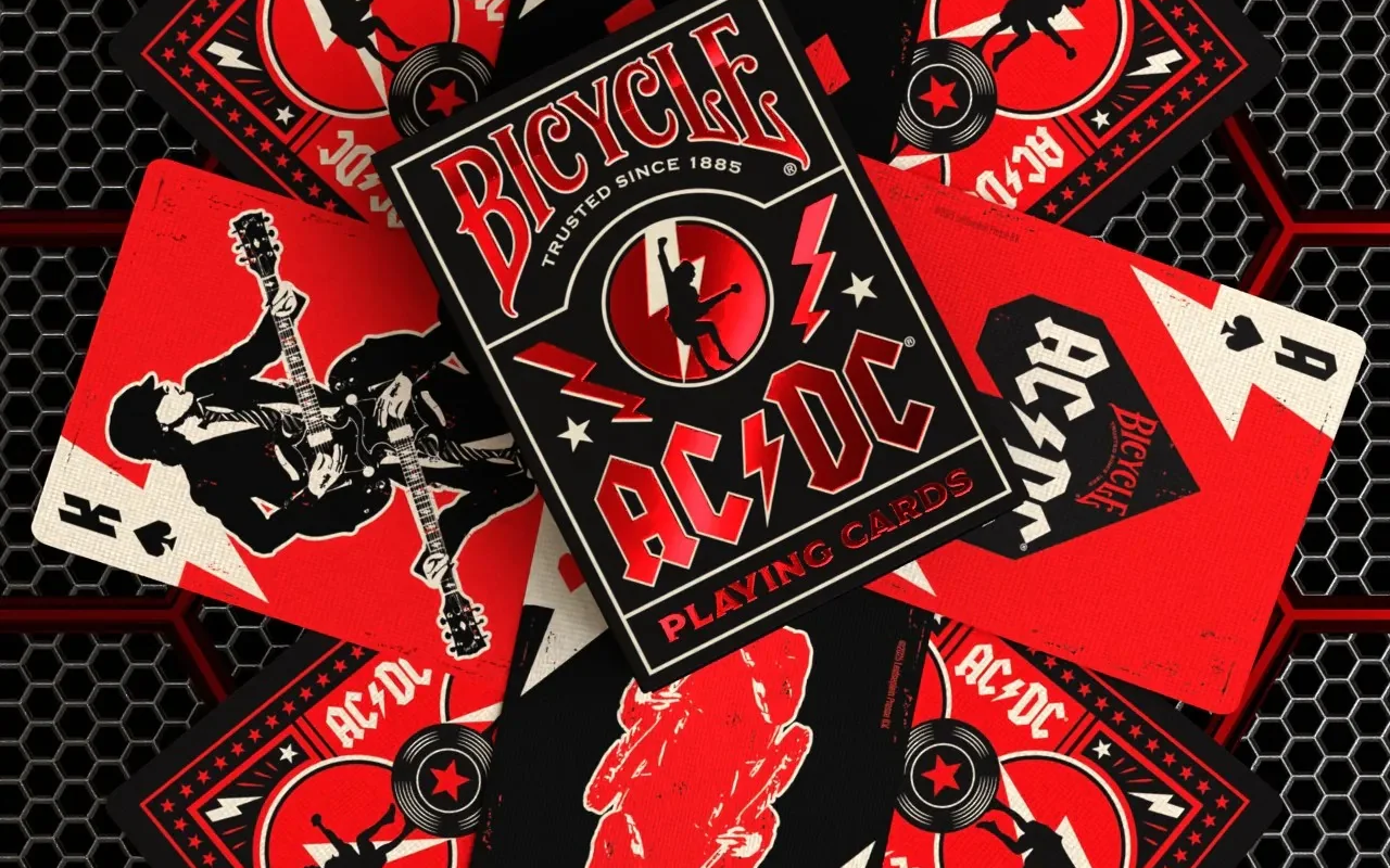 Black and red Bicycle AC/DC Playing Cards deck box and scattered cards featuring rock band artwork