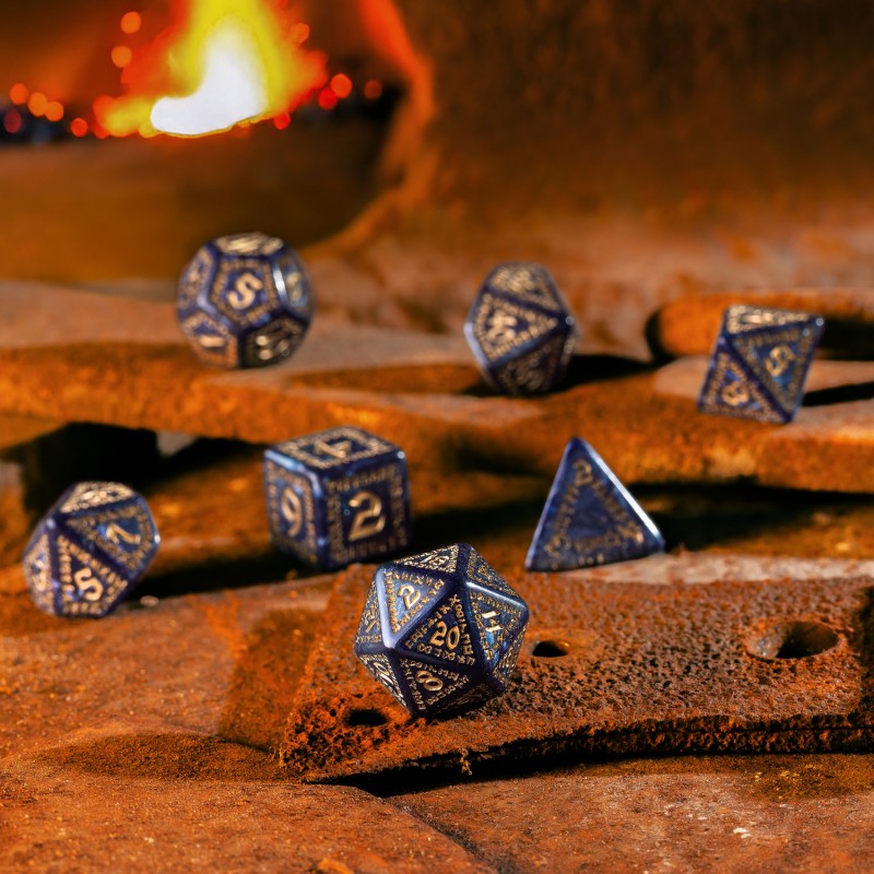 Dark blue and gold RPG dice are scattered on a rusty metal surface, with a warm forge fire in the background