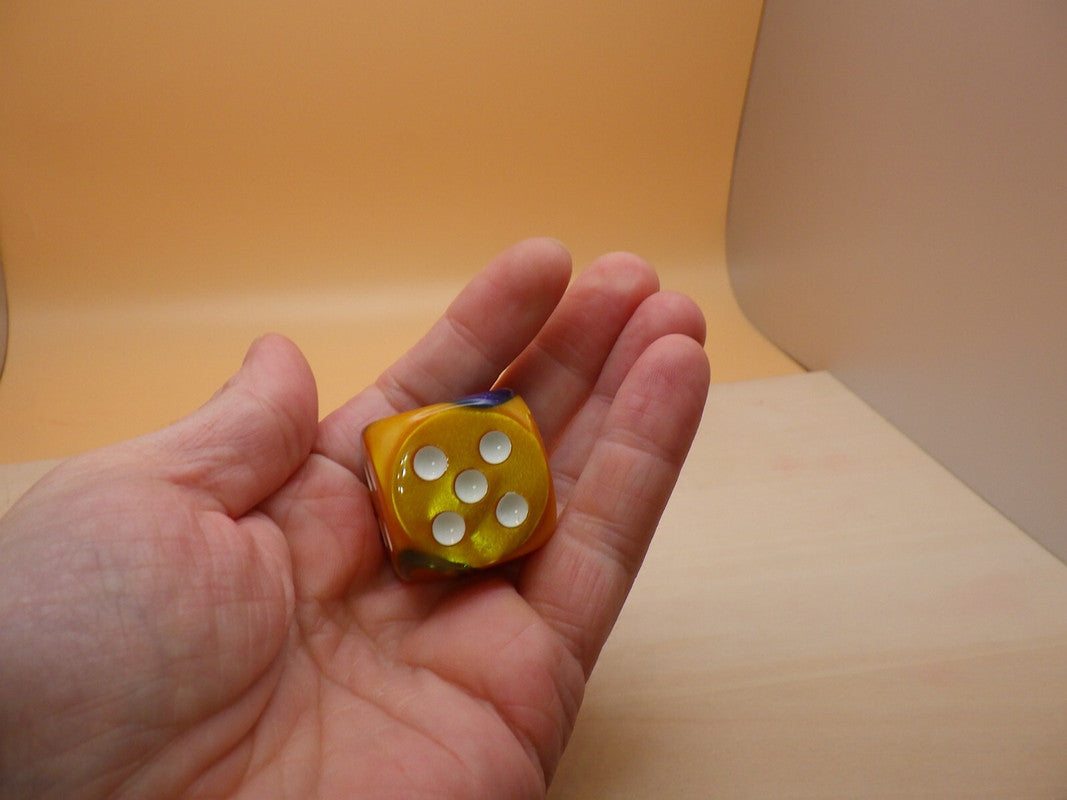 Masquerade Yellow and White die showing five white pips held in a hand