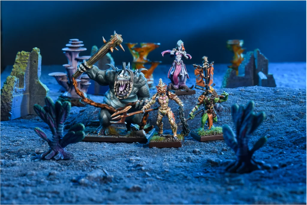 Kings of War Trident Realm Hero Pack miniatures, including a colossal monster, sea elves, and other aquatic creatures, in a display setting