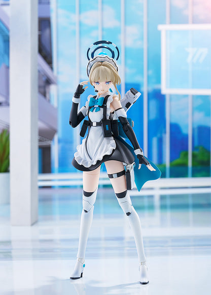 Blonde anime figure in a maid outfit with blue accents and futuristic armor, posing in a modern, light blue room