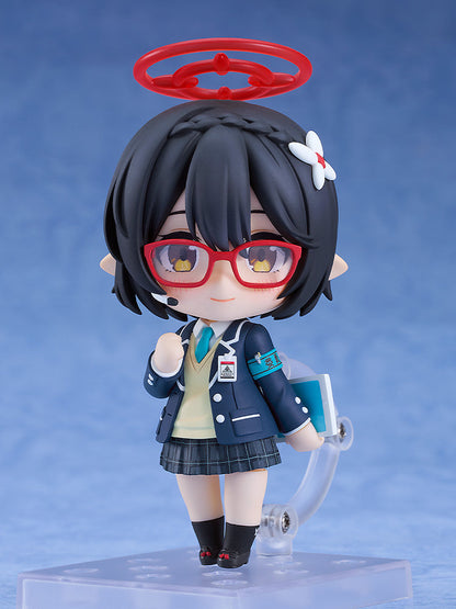 A Nendoroid figure of a black-haired character with red glasses, red halo, and school uniform, holding a book