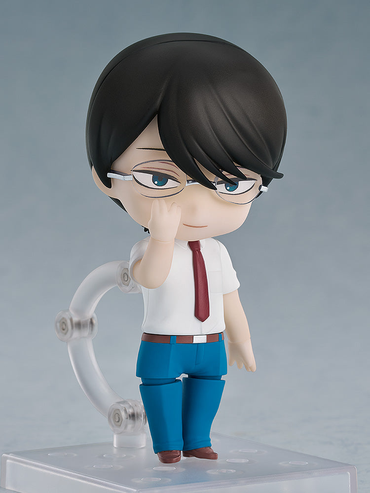 A chibi-style figure of a man with black hair, glasses, white shirt, and red tie, gently touching his glasses