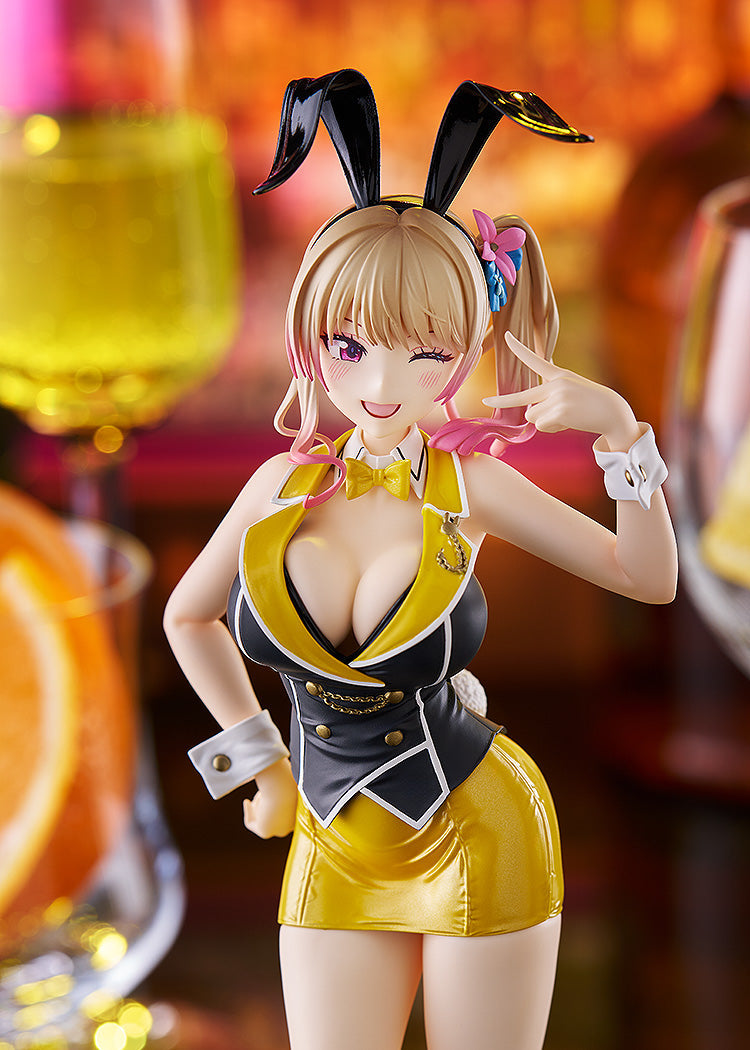 A blonde anime figure with black bunny ears, in a black & yellow outfit, winks and makes a V-sign