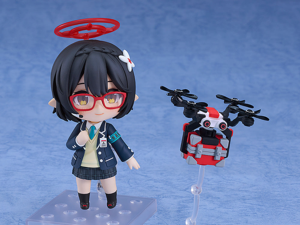 Nendoroid schoolgirl figure with red glasses & halo stands by a red & black drone