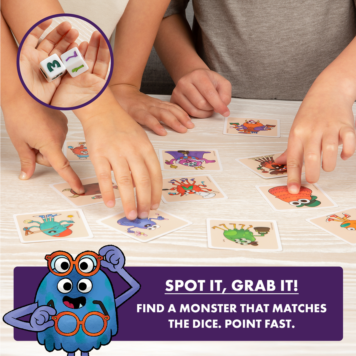 Kids&#39; hands play a monster card matching game. One hand holds dice showing 3 &amp; 7; others point at cards
