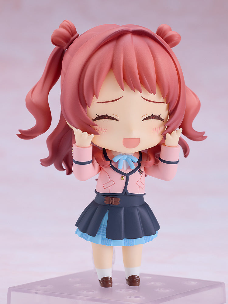 Good Smile Company Nendoroid Saki Hanami figure smiles joyfully with closed eyes and raised hands, dressed in a pink jacket and blue pleated skirt, standing on a clear display base