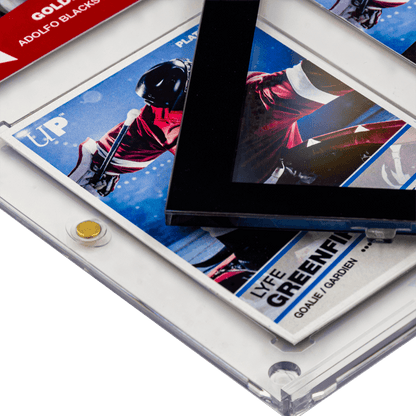A stack of hockey cards in clear Ultra Pro One Touch protectors, one featuring a black border around a player in a red jersey
