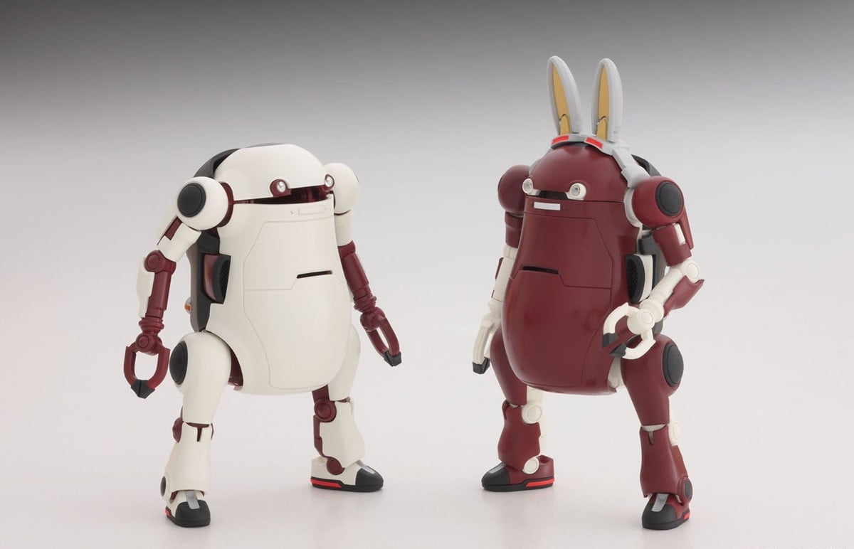 Two round robot model kits, one white and one maroon with large rabbit ears, standing side-by-side
