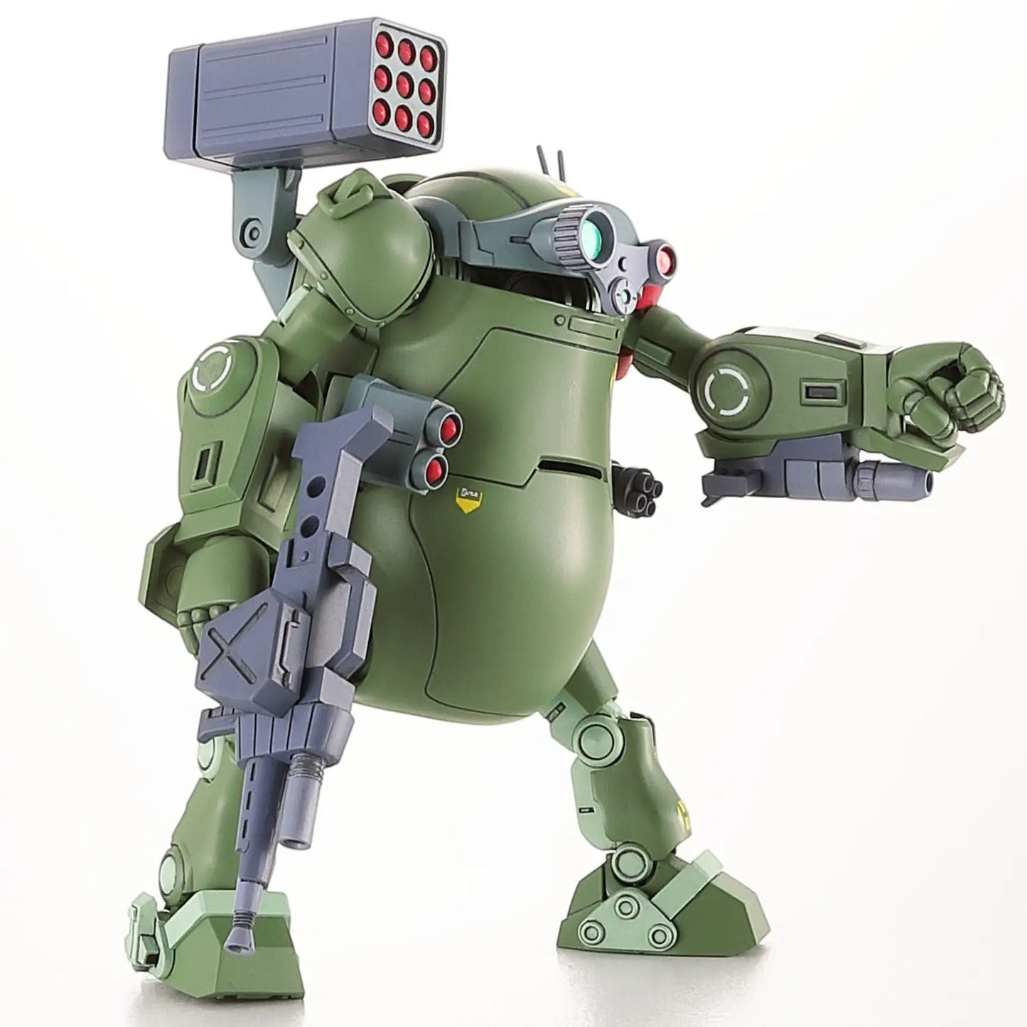 Green military robot model with a shoulder missile pod, rifle and a raised fist