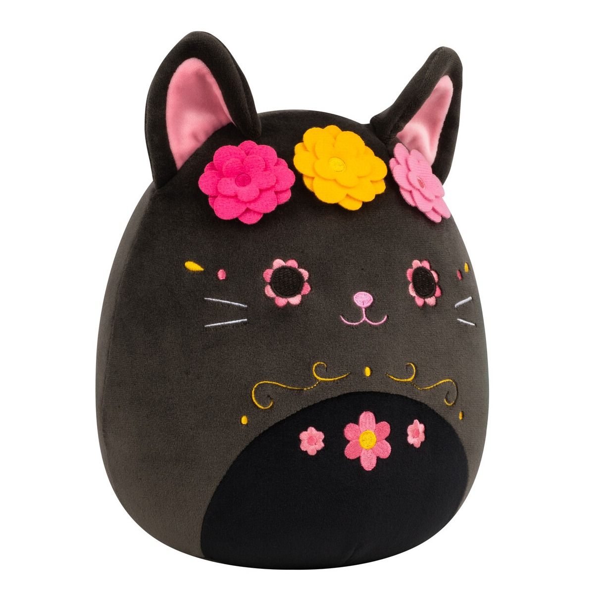 An adorable 8-inch Day of the Dead black Squishmallow cat featuring pink ears a vibrant flower crown and detailed pink and gold embroidered sugar skull facial markings