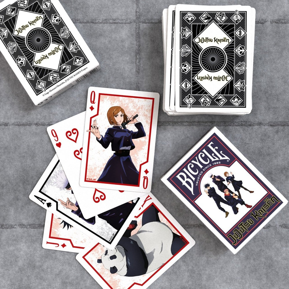 Bicycle playing cards featuring Jujutsu Kaisen characters scattered on a table, including Nobara, Gojo, and Panda